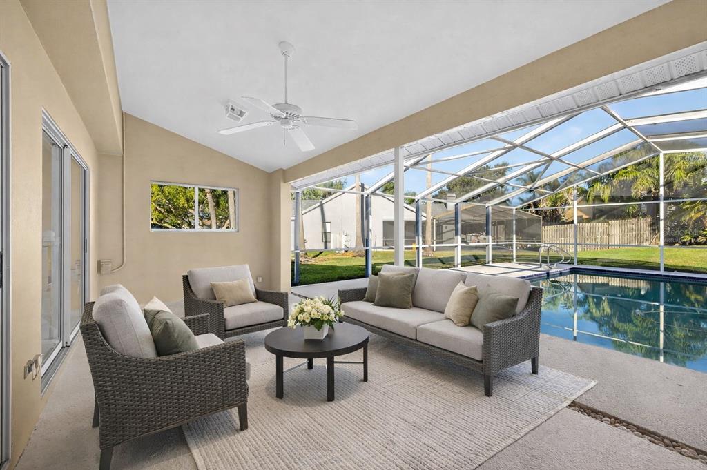 1819 Tree Swallow Way Palm Harbor, FL 34683 - Photo 30 of 39 a living room with furniture and a floor to ceiling window