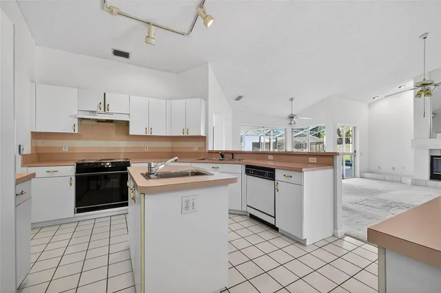 a kitchen with a stove sink and cabinets