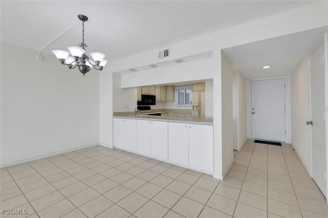15010 Punta Rassa Road, Unit 305 Fort Myers, FL 33908 - Photo 12 of 21 a view of a kitchen with kitchen island granite countertop cabinets and stainless steel appliances