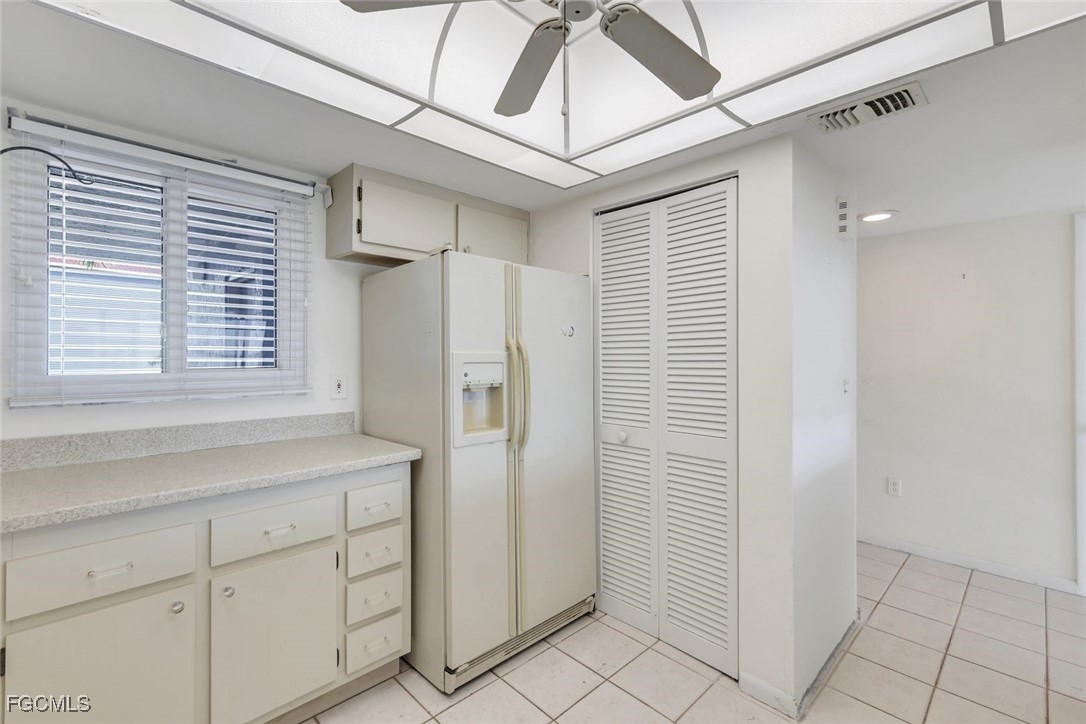 15010 Punta Rassa Road, Unit 305 Fort Myers, FL 33908 - Photo 9 of 21 a kitchen with white cabinets and refrigerator
