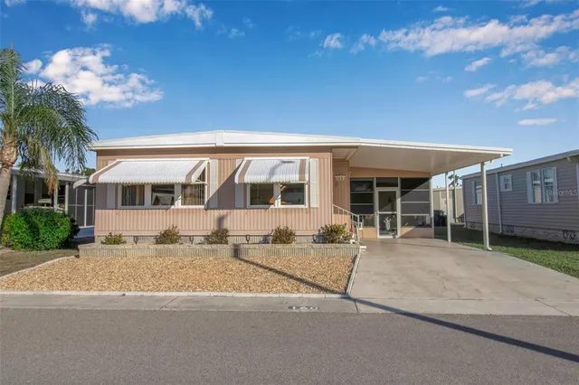 a front view of a house with a yard and potted plants