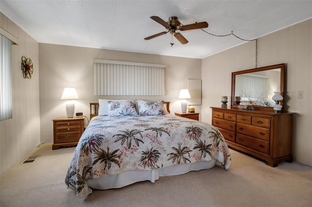 5619 Bayshore Road, Unit 160 Palmetto, FL 34221 - Photo 11 of 30 a bedroom with a bed a dresser and painting on the wall