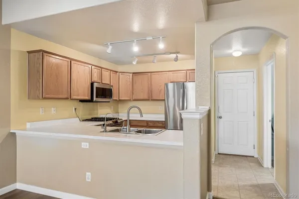 a kitchen with stainless steel appliances a refrigerator sink and microwave