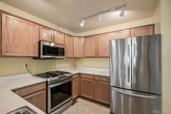 a kitchen with stainless steel appliances granite countertop a refrigerator stove and microwave