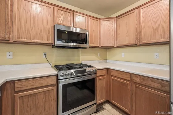 a kitchen with granite countertop wood cabinets stainless steel appliances and a sink