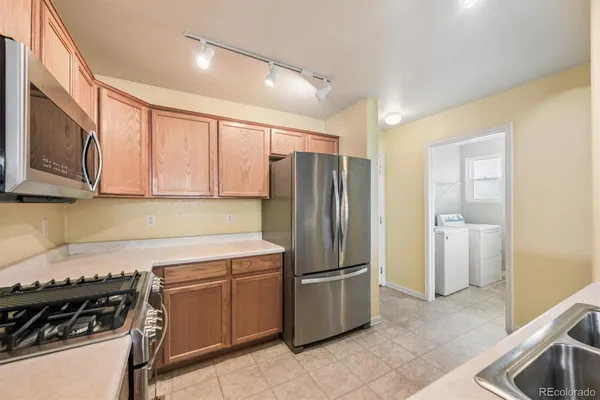a kitchen with a refrigerator and a stove top oven