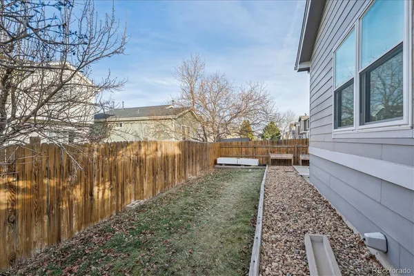 a view of a yard with wooden fence
