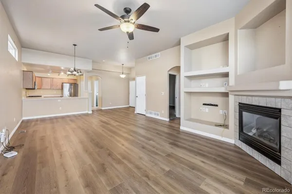 an empty room with kitchen and fireplace