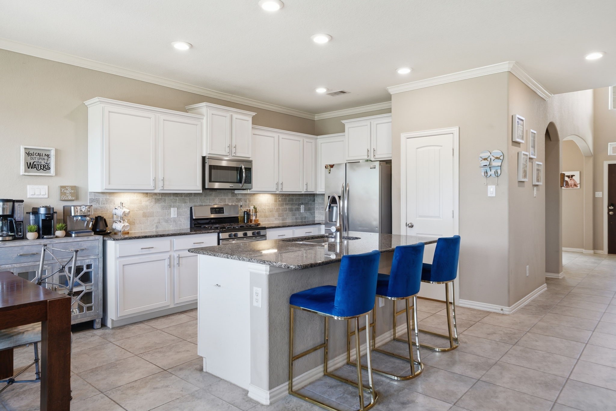 13207 Alcott Forest Lane Rosharon, TX 77583 - Photo 9 of 44 Welcome to your kitchen which features a center island and stainless steel appliances. The walk-in pantry is adjacent to the fridge. The utility room is conveniently located on your right.