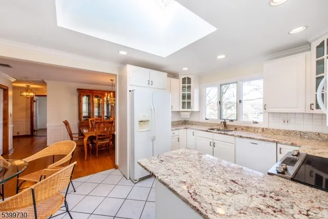 a large kitchen with kitchen island a dining table chairs and refrigerator