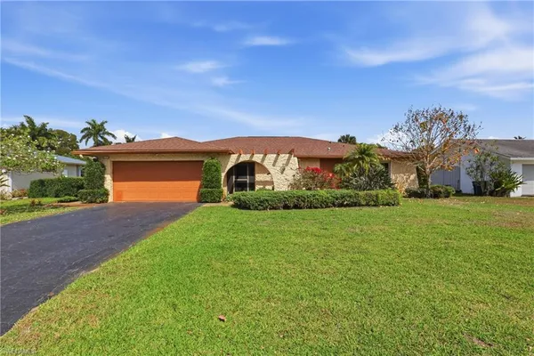a front view of a house with a garden and yard