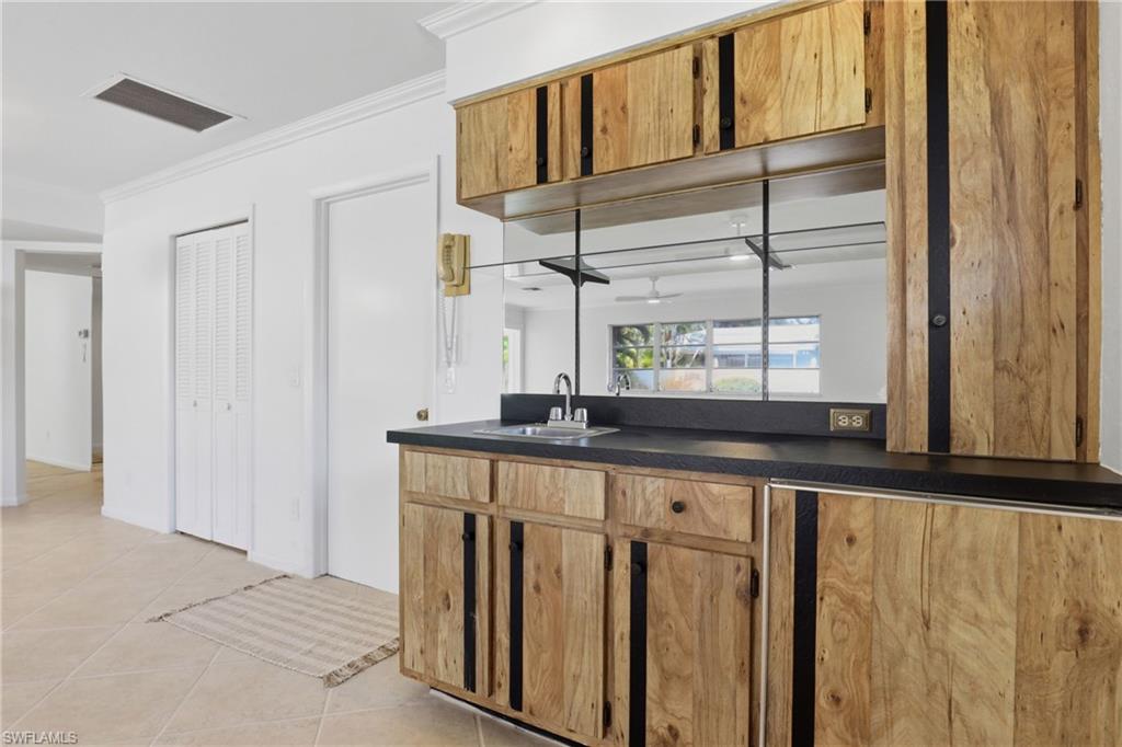 135 Pebble Beach Boulevard Naples, FL 34113 - Photo 11 of 37 a kitchen with windows a sink and cabinets