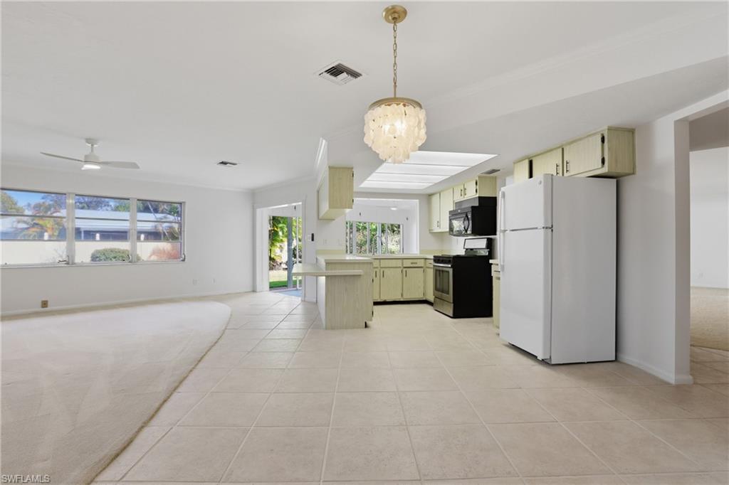 135 Pebble Beach Boulevard Naples, FL 34113 - Photo 21 of 37 a view of a kitchen with refrigerator and windows