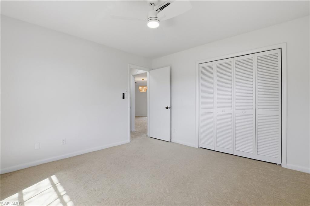 135 Pebble Beach Boulevard Naples, FL 34113 - Photo 31 of 37 an empty room with a ceiling fan and closet area