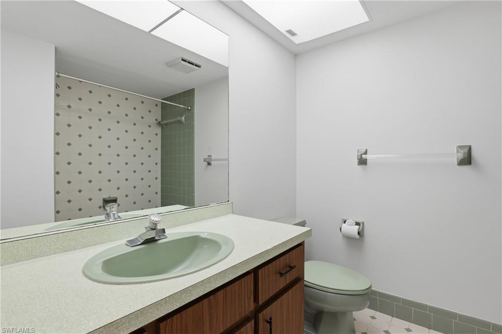 135 Pebble Beach Boulevard Naples, FL 34113 - Photo 32 of 37 a bathroom with a sink toilet and a mirror