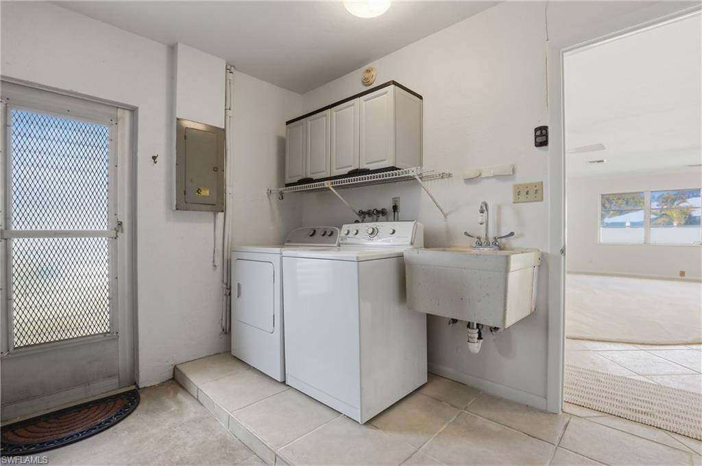 135 Pebble Beach Boulevard Naples, FL 34113 - Photo 33 of 37 a utility room with cabinets washer and dryer