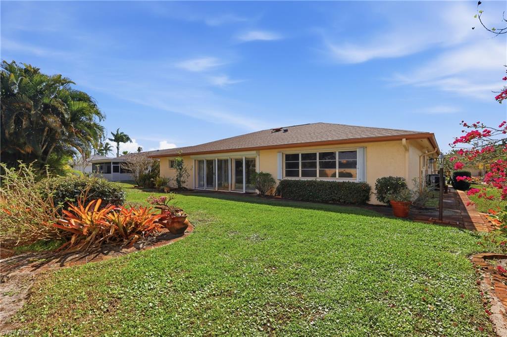 135 Pebble Beach Boulevard Naples, FL 34113 - Photo 34 of 37 a front view of a house with a yard
