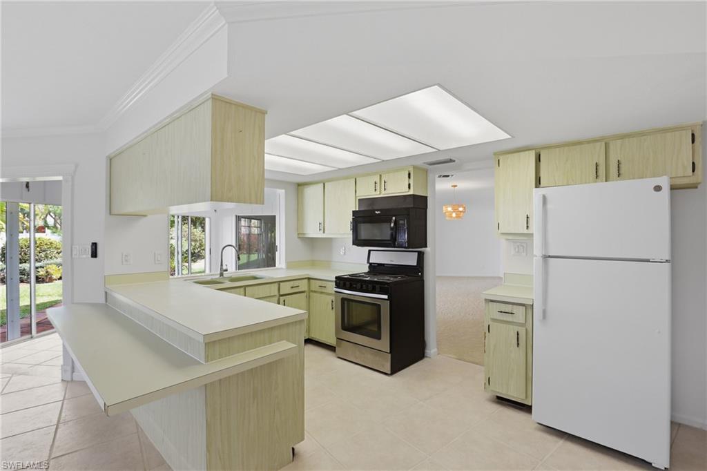 135 Pebble Beach Boulevard Naples, FL 34113 - Photo 10 of 37 a kitchen with a refrigerator a stove top oven a sink and dishwasher