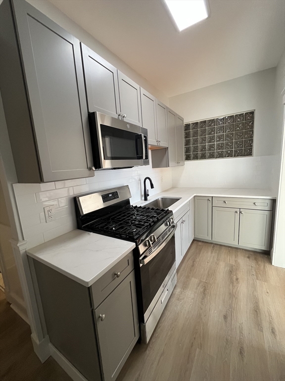 108 Bristol Road, Unit 1 Somerville, MA 02144 - Photo 4 of 24 a kitchen with a sink stove and microwave