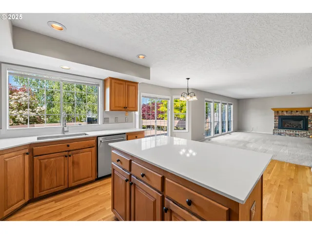 a kitchen with kitchen island granite countertop a sink stove and cabinets