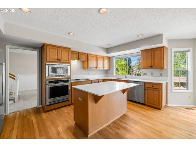 a kitchen with stainless steel appliances granite countertop a stove a sink and a refrigerator