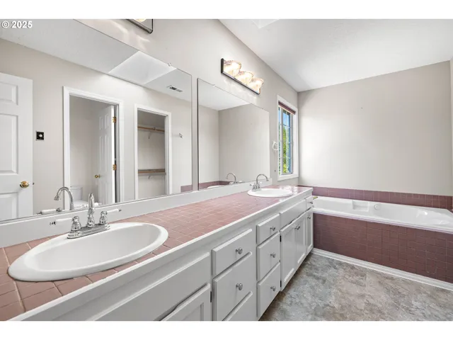 a bathroom with a granite countertop sink a large mirror and a bathtub