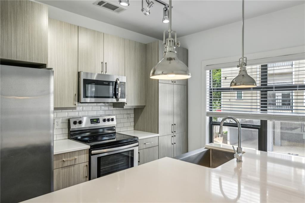 36 Moda Lane Atlanta, GA 30307 - Photo 8 of 26 a kitchen with stainless steel appliances kitchen island granite countertop a stove a sink and a refrigerator