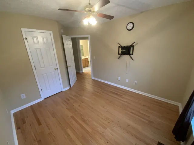 an empty room with wooden floor and windows