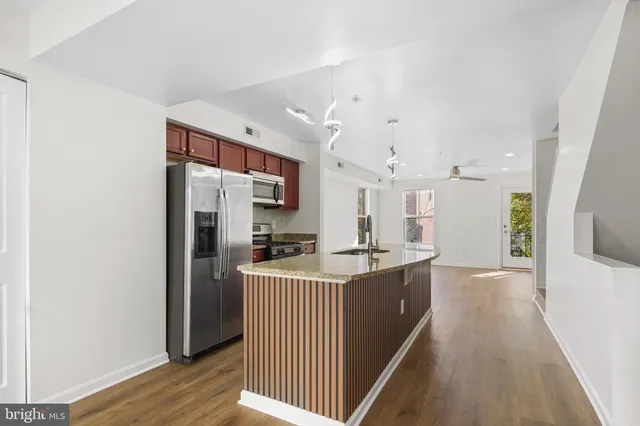 a kitchen with stainless steel appliances granite countertop a sink microwave and wooden floor