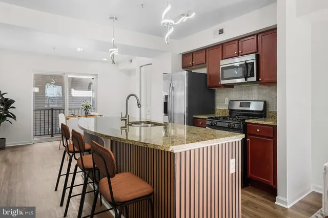 a kitchen with stainless steel appliances kitchen island granite countertop a dining table and chairs