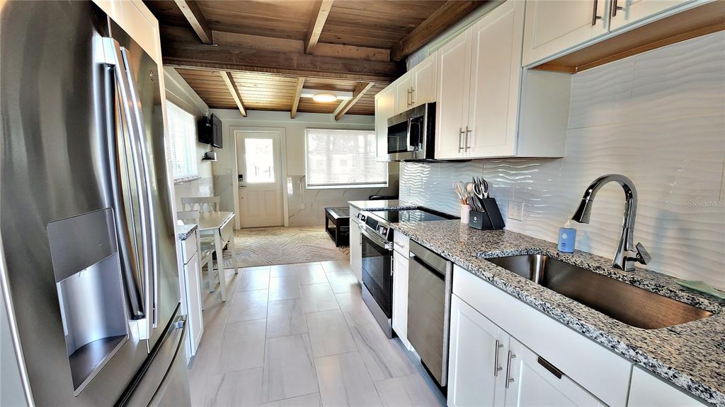 Undisclosed Address Englewood, FL 34223 - Photo 8 of 24 a kitchen with a sink a refrigerator and cabinets