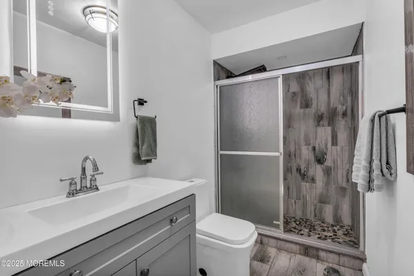 a bathroom with a sink toilet a mirror and shower