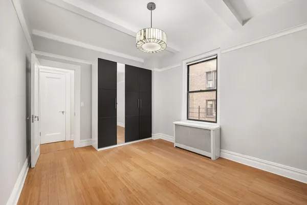 a bedroom with a large bed and a chandelier