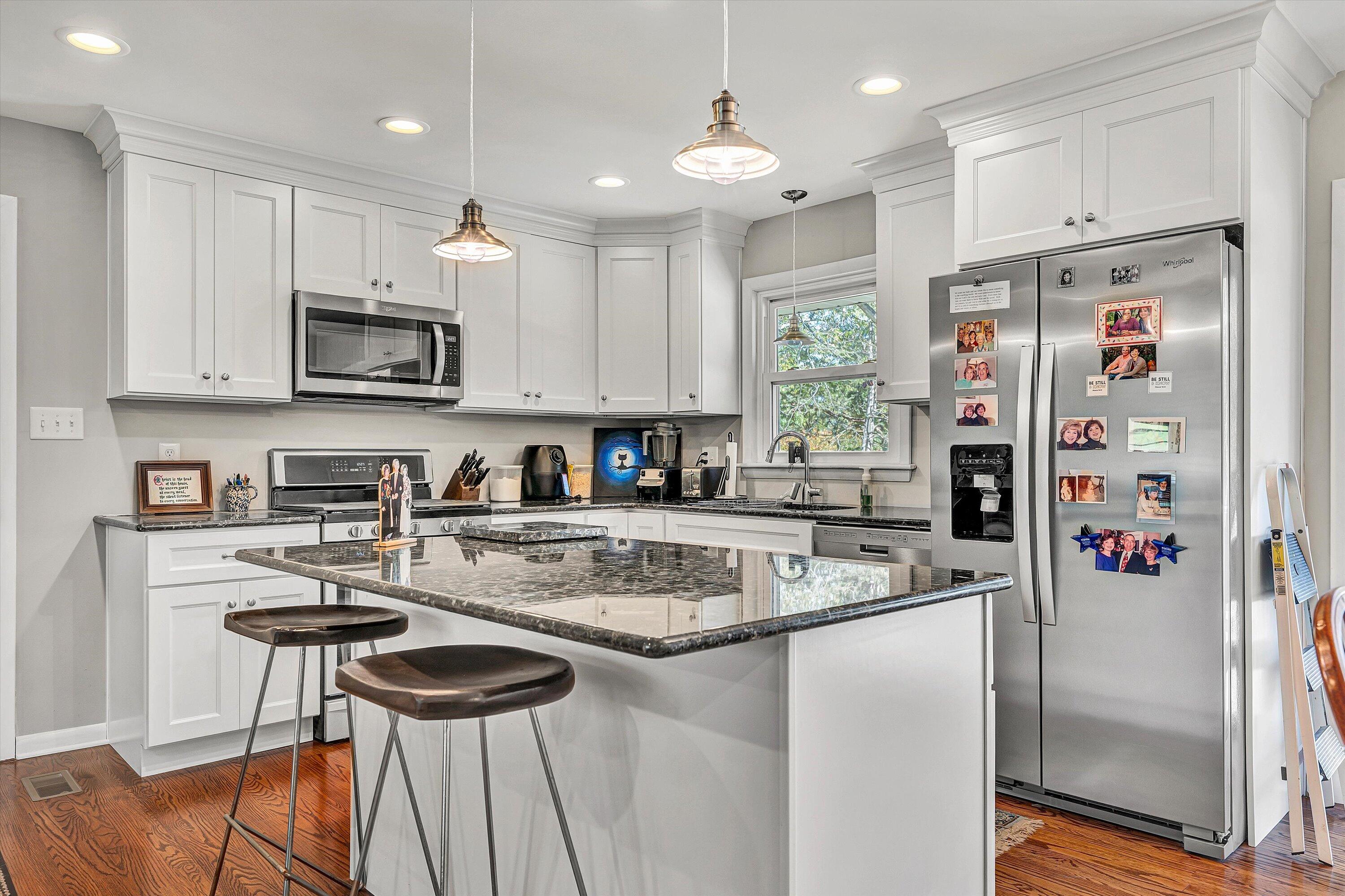 2312 Kipling Street Southwest Roanoke, VA 24018 - Photo 14 of 52 a kitchen with stainless steel appliances granite countertop a refrigerator a stove a sink a dining table and chairs with wooden floor