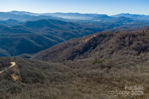 a view of a house with a mountain and a forest