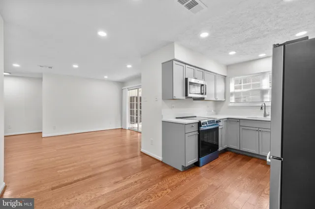 a kitchen with a refrigerator and a stove top oven