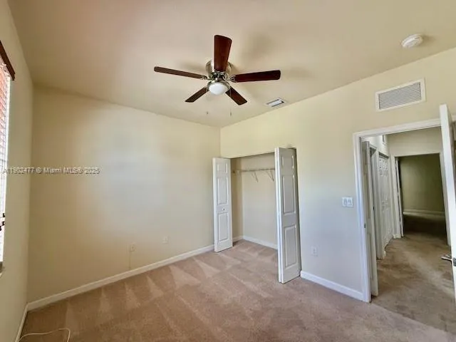 a view of empty room with ceiling fan