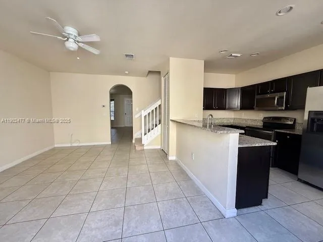 a kitchen with stainless steel appliances granite countertop a refrigerator and a stove top oven