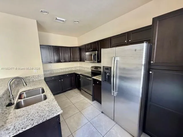 a kitchen with a refrigerator sink and cabinets