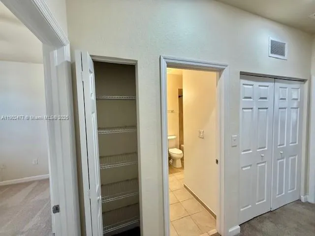 a view of bathroom with a closet and mirror