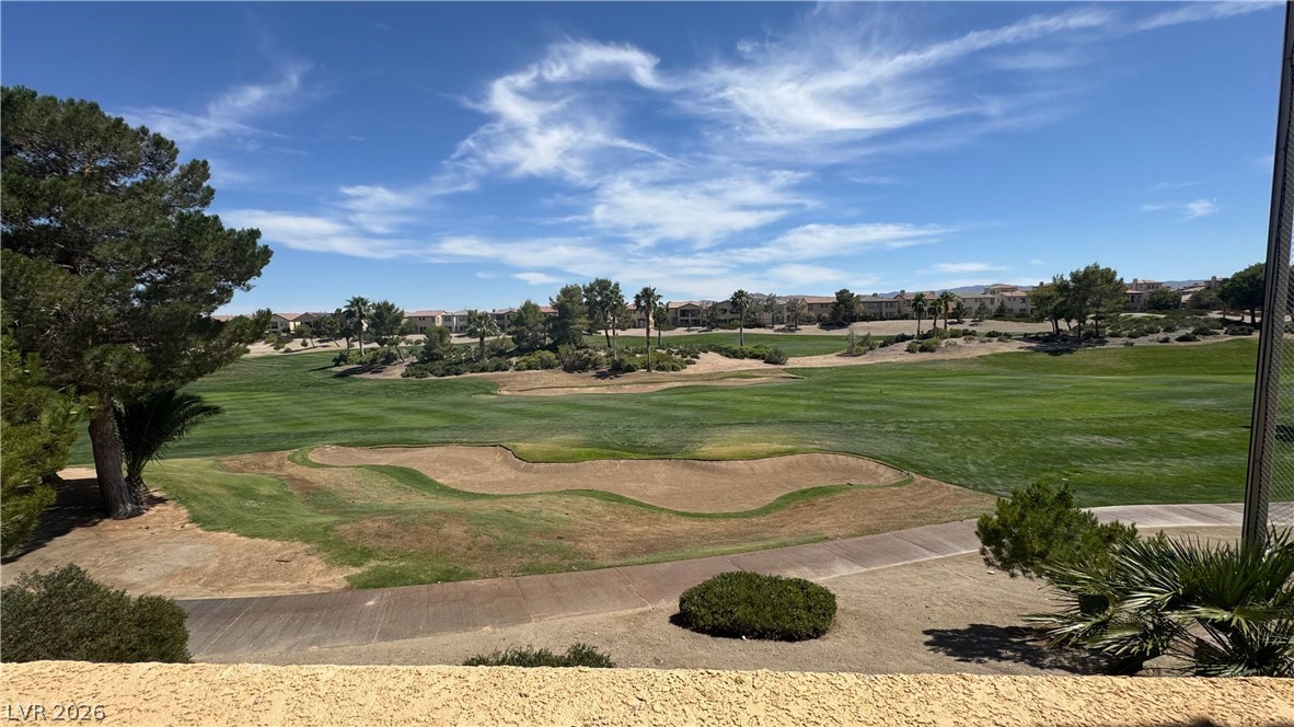 87 Tall Ruff Drive Las Vegas, NV 89148 - Photo 35 of 71 A golfer's dream, featuring green fairways and sand traps against a backdrop of distant homes.