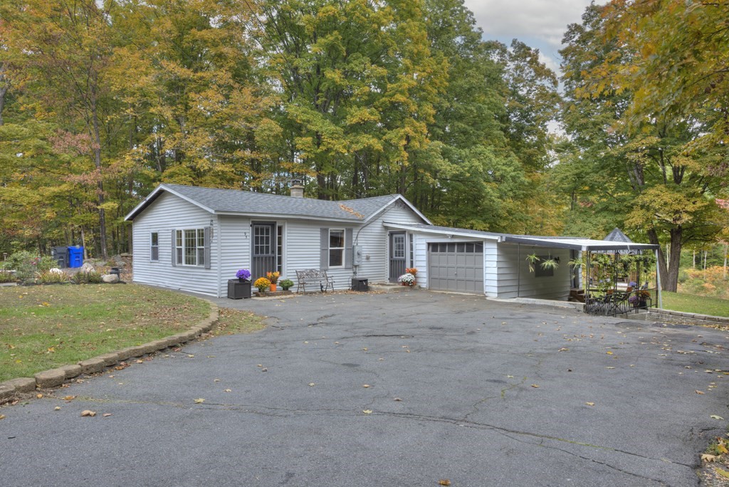 a view of a house with a yard and large tree