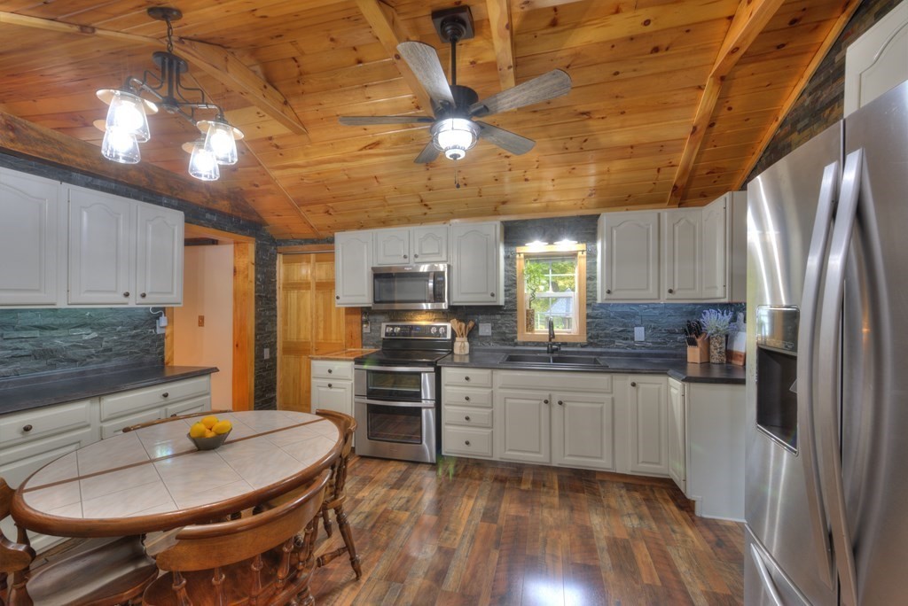 95 Sylvester Road Northampton, MA 01062 - Photo 13 of 42 a kitchen with stainless steel appliances granite countertop a sink a stove a refrigerator cabinets and chairs