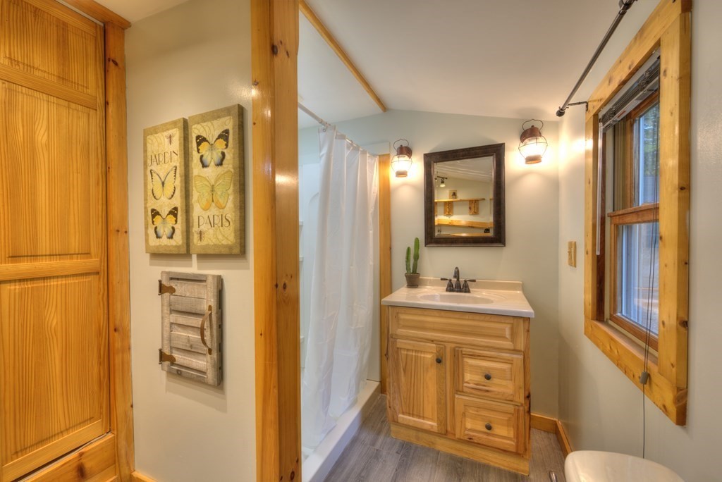 95 Sylvester Road Northampton, MA 01062 - Photo 18 of 42 a en suite bathroom with a sink a mirror a bathtub and window