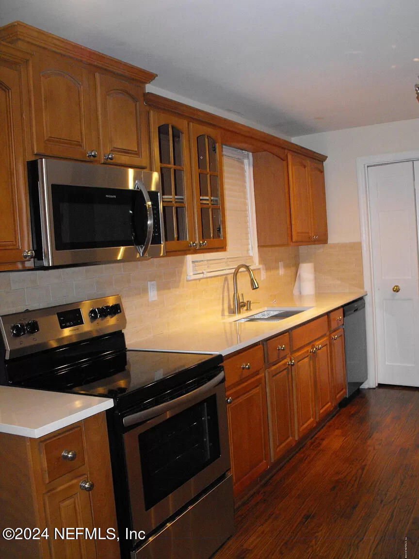 a kitchen with stainless steel appliances a stove a microwave and sink