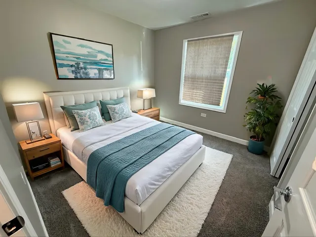 a bedroom with bed and a potted plant