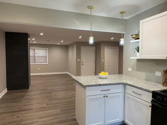 a kitchen with a sink cabinets and wooden floor