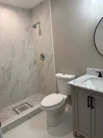 a bathroom with a granite countertop toilet sink and shower