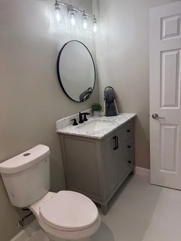 a bathroom with a toilet a sink and a mirror