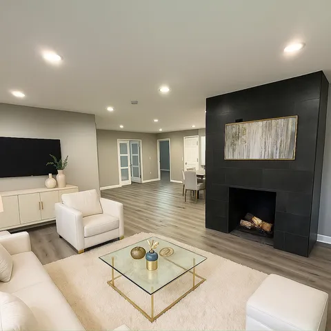 a living room with furniture a flat screen tv and a fireplace